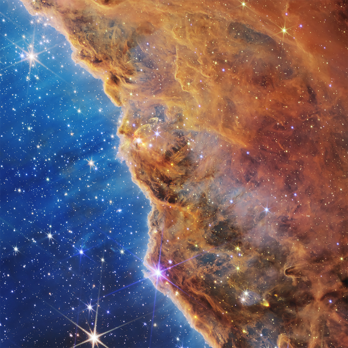 A cutout of the Cosmic Cliffs, a vast gaseous nebular, turned on its side to perhaps vaguely resemble the coastline of California.